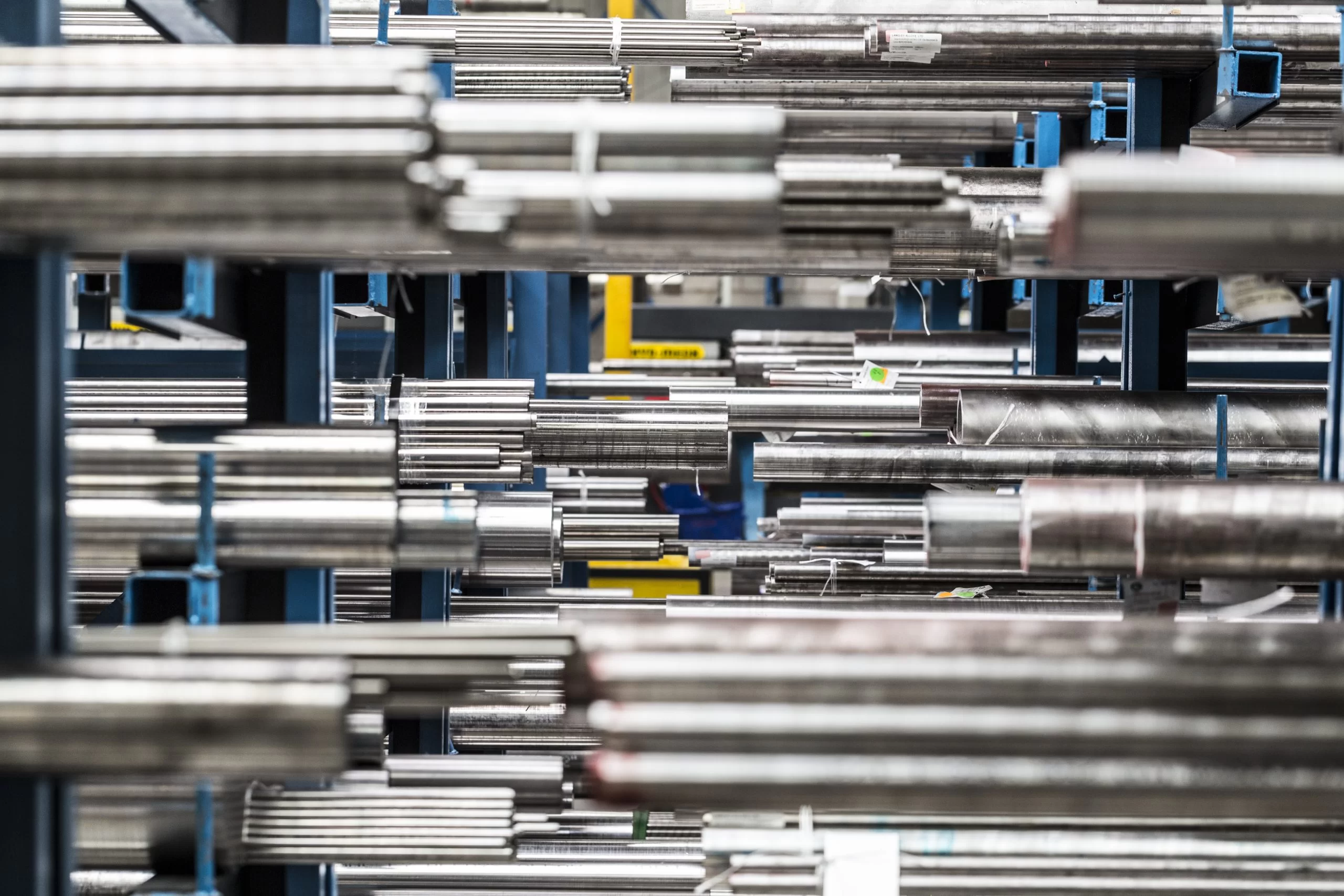 An array of metal pipes on blue shelving