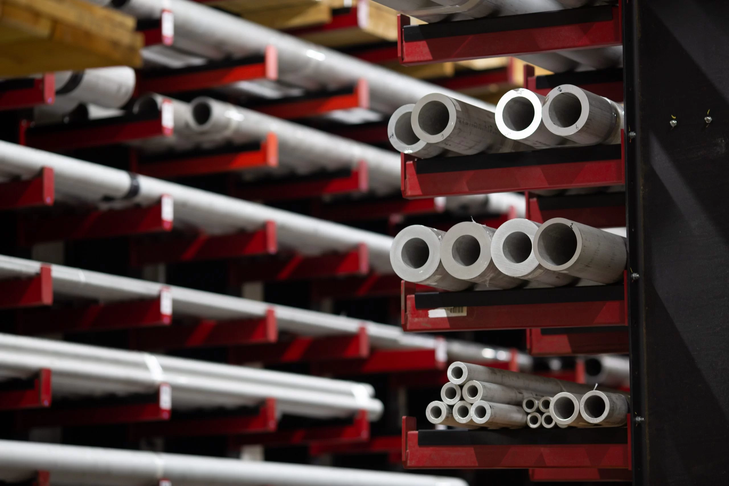 Alloy pipes on red shelving